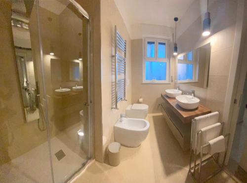 ein Badezimmer mit zwei Waschbecken, einem WC und einer Dusche in der Unterkunft Albadorata in Praia a Mare