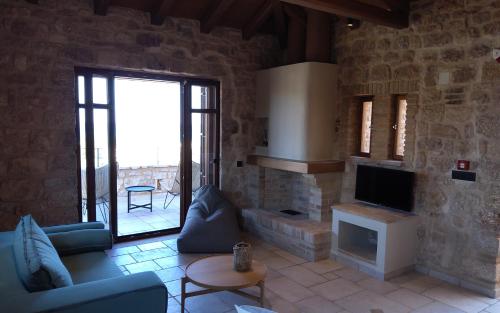 ein Wohnzimmer mit einem Sofa und einem TV in der Unterkunft Harmony Seaview Villas In Elafonisos in Elafonisos