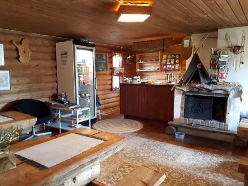 uma sala de estar com lareira num chalé de madeira em Lätasenonmajat em Enontekiö