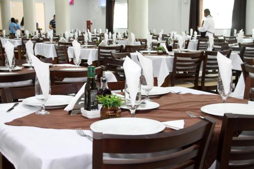 a dining room with tables and chairs with wine bottles at Miotto Executive Hotel in Navegantes