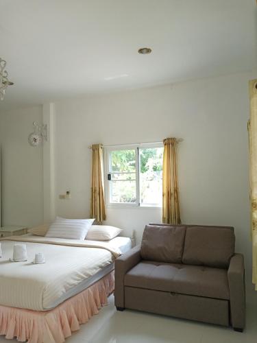 a bedroom with two beds and a couch and a window at Wandee Resort Bankrut in Ban Krut