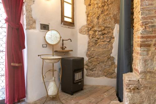 Habitación con TV y espejo en la pared. en Un Pezzo di storia vicino al mare en Rosignano Marittimo