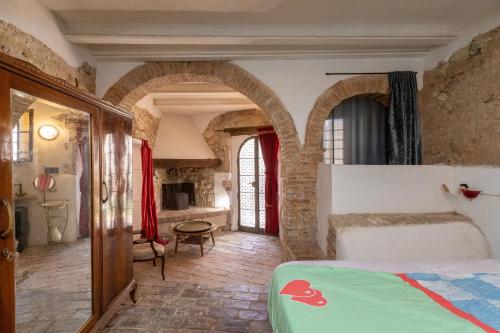 1 dormitorio con arcos y 1 cama en una habitación en Un Pezzo di storia vicino al mare en Rosignano Marittimo
