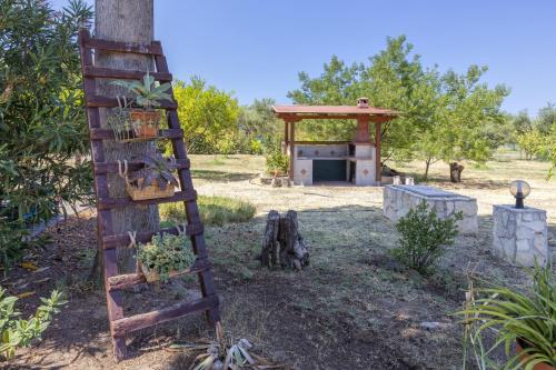 a garden with a wooden ladder and a building at La Casa di Valverde in Alghero