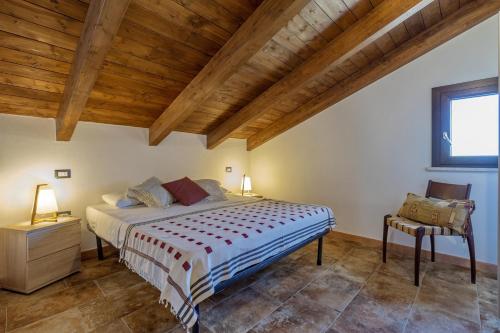 a bedroom with a bed and a wooden ceiling at La Casa di Valverde in Alghero