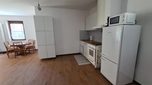eine Küche mit einem weißen Kühlschrank und einem Tisch in der Unterkunft Appartamento Ticino in Monte Carasso