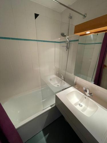 une salle de bain avec un lavabo, une baignoire et un miroir dans l'établissement PLAGNE BELLECOTE - 5 Pers - Vue Pistes - Acces Piscine chauffee, à Plagne Bellecôte
