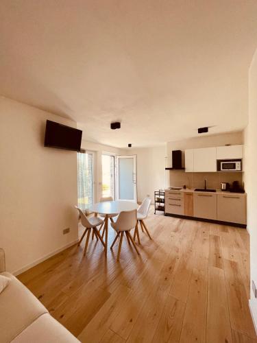 een woonkamer met een tafel en stoelen en een keuken bij Tellure apartments with breakfast in Berbenno di Valtellina