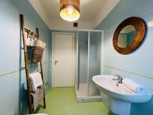 a bathroom with a sink and a mirror and a shower at Beach apartments Spiaggia Nascosta in Silvi Marina
