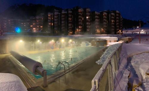 - une piscine couverte de neige la nuit dans l'établissement PLAGNE BELLECOTE - 5 Pers - Vue Pistes - Acces Piscine chauffee, à Plagne Bellecôte