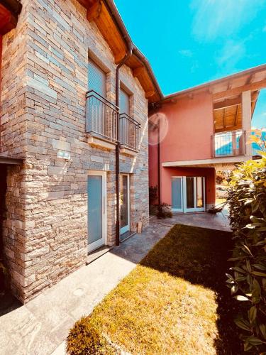 Una casa de ladrillo con un balcón en el lateral. en Tellure apartments with breakfast, en Berbenno di Valtellina
