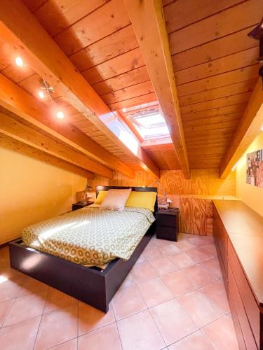 a bedroom with a bed in a room with wooden ceilings at Appartamento vista colline in Cavola