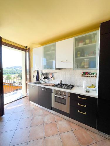 a kitchen with a stove and a large window at Appartamento vista colline in Cavola