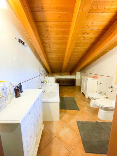 a large bathroom with two toilets and a sink at Appartamento vista colline in Cavola