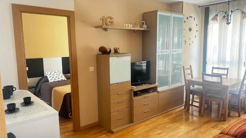 サラゴサにあるEl Primero G Zaragoza - Aljaferíaのベッド1台、テーブル、テレビが備わる小さな客室です。