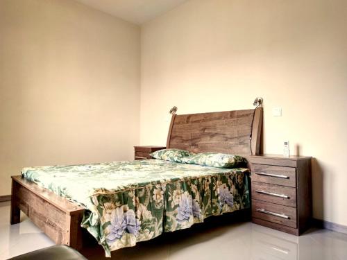 sypialnia z drewnianym łóżkiem i drewnianą komodą w obiekcie Praia Capital Residence Aparthotel w mieście Praia