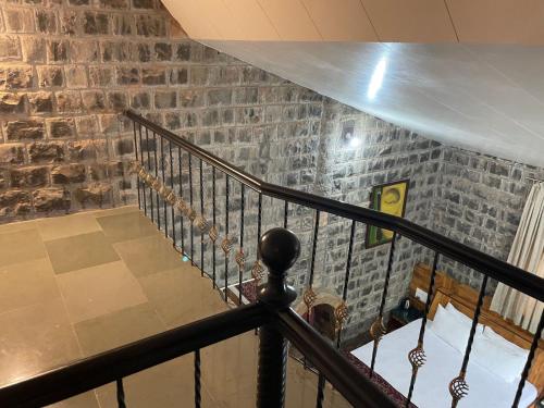 a spiral staircase with a brick wall at The Green Gate Resort Mulshi in Pune