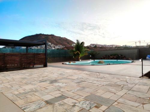 a backyard with a swimming pool and a fence at Praia Capital Residence Aparthotel in Praia