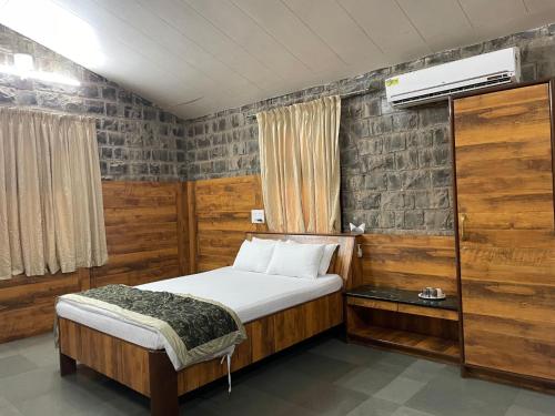 um pequeno quarto com uma cama e uma janela em The Green Gate Resort Mulshi em Pune