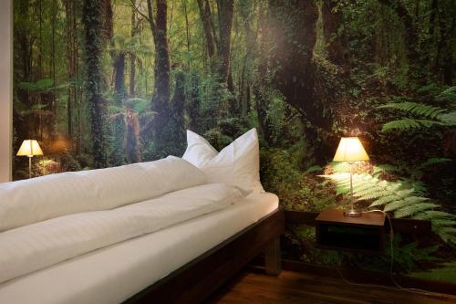 sypialnia z łóżkiem z leśnym malowidłem w obiekcie Gasthof Löwen Herznach w mieście Herznach