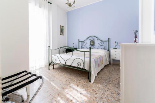 a white bedroom with a bed and a chair at Casa Sofocle Comodo bivani a Siracusa posto nell'antico quartiere della Borgata in Syracuse