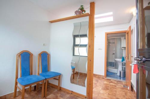 um quarto com duas cadeiras azuis e um espelho em Apartma Bajc em Ajdovščina