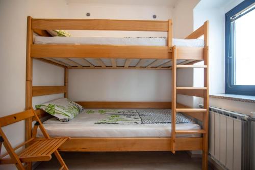 a bedroom with two bunk beds and a window at Apartma Bajc in Ajdovščina
