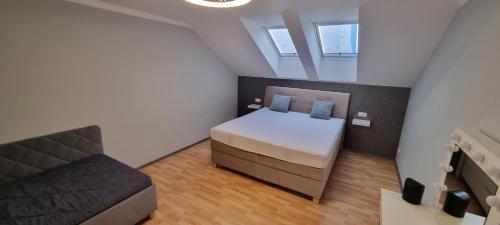 a small bedroom with a bed and a couch at Apartmán Viktorie in Mikulov