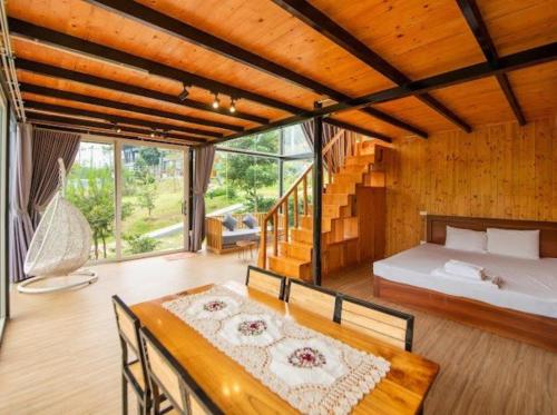 ein Schlafzimmer mit einem Bett und einem Tisch in einem Zimmer in der Unterkunft Villa de Montana in Ba Vì