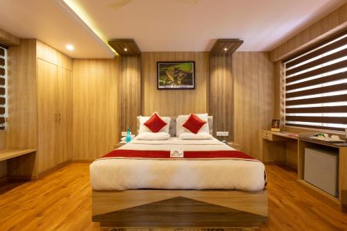 a hotel room with a large bed with red pillows at KSTDC Hotel Mayura Riverview Srirangapatna in Seringapatam