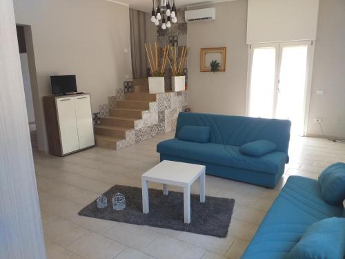 - un salon avec un canapé bleu et une table dans l'établissement Dimora Aminidelo, à Maruggio