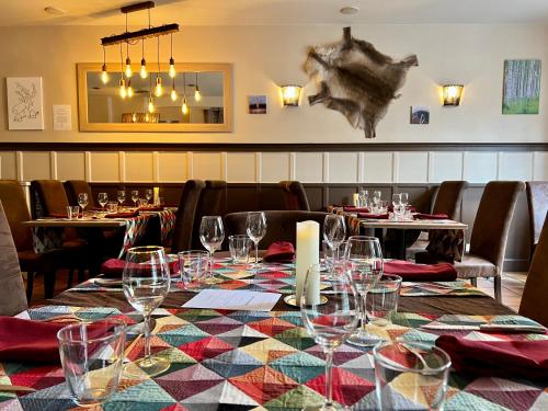 un comedor con una mesa con copas de vino en Logis Hôtel des Causses, en Millau