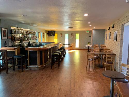 un restaurante con bar, mesas y sillas en Villa Inn en San Rafael