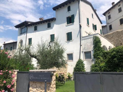 un bâtiment blanc avec un panneau devant lui dans l'établissement Villa Borgo Borago, à Brenzone