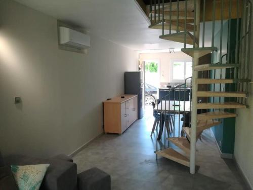 un salon avec un escalier en colimaçon et une table dans l'établissement Gîte des Tamarins à Saint-Pierre la Mer, à Fleury