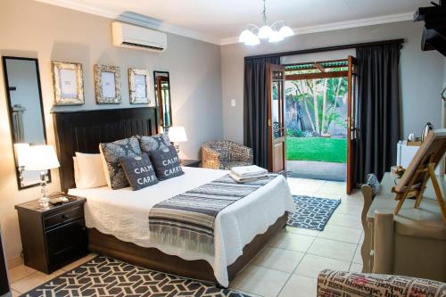 Four Seasons Guesthouses في Lephalale: غرفة نوم بسرير وباب الى ساحة