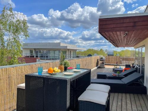 a patio with a table and chairs on a deck at Skyhouse Riga Lux Penthouse & SPA in Rīga