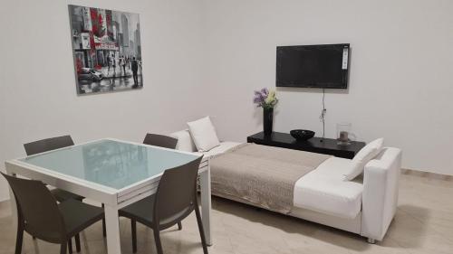 una camera con letto, tavolo e TV di That's amore Brindisi beach a Brindisi