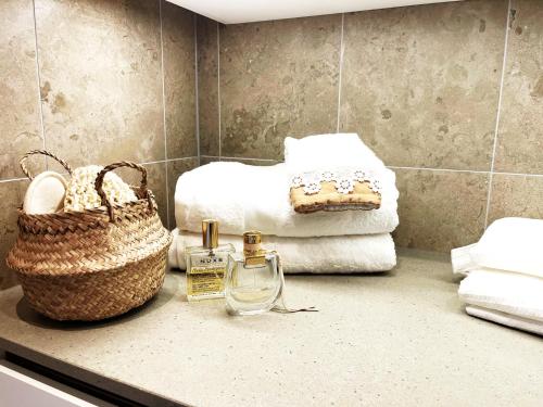 a bathroom with towels and a basket on a counter at Stadsporten Nacka in Nacka