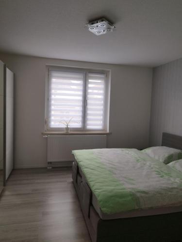 a bedroom with a bed and a window at Ferienwohnung Bianca in Nordhausen