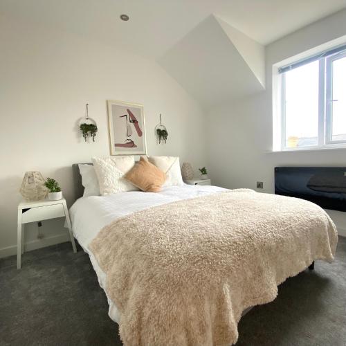 a white bedroom with a large bed and a window at Modern 2 Bed Apartment/Free Parking/Near City/Self-Check In in Handsworth
