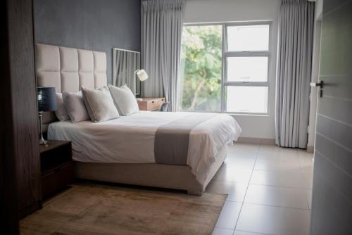 a bedroom with a large bed and a window at Stays With DMWA in Johannesburg