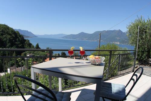 a table and chairs on a balcony with a view of the water at Casa Colmegna mit traumhaften See- und Bergblick in Luino