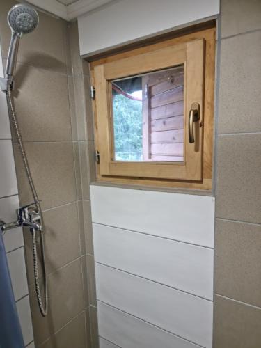 a bathroom with a shower with a window in it at Holiday Home SAJRA in Kulen Vakuf