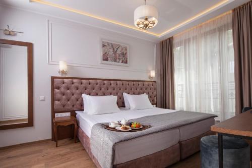 a hotel room with a bed with a tray of fruit on it at Villa Flavia Heritage Boutique Hotel in Plovdiv