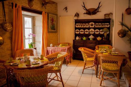 une salle à manger avec tables et chaises et une cuisine dans l'établissement Auberge de la Fontaine, à Villiers-sur-Suize