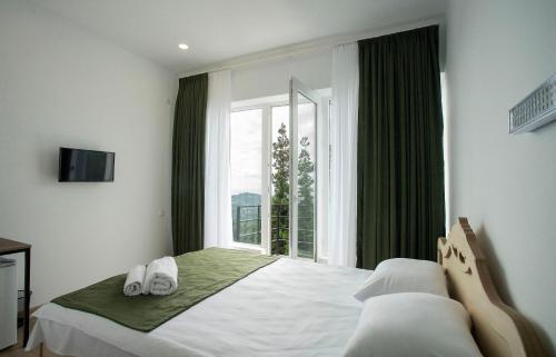 a bedroom with a bed and a large window at Limonchelo in Kobuleti