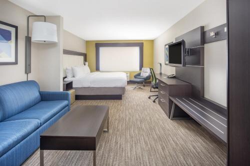 a hotel room with a couch and a bed and a tv at Holiday Inn Express Hotel & Suites Bishop, an IHG Hotel in Bishop