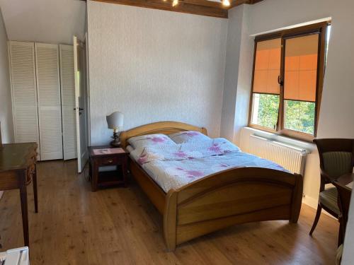 1 dormitorio con cama de madera y ventana en Gościniec Zośka, en Ostrzyce