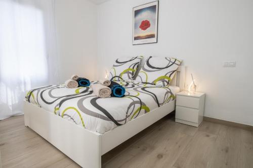 een witte slaapkamer met een bed met bloemen erop bij Casita Emma in Playa Blanca